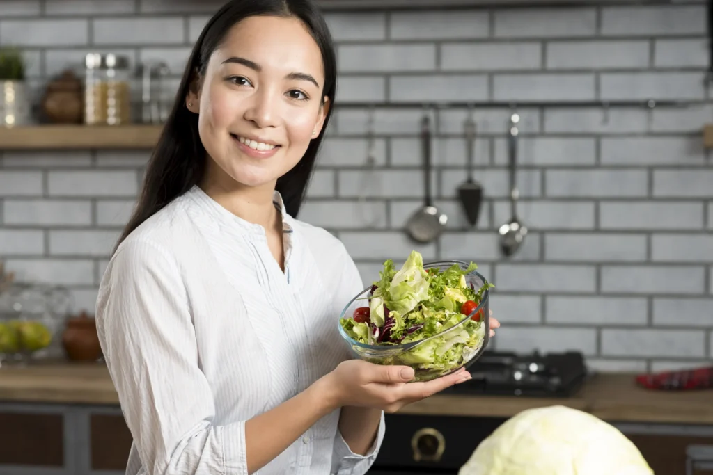 Woman holding a bowl of salad at home