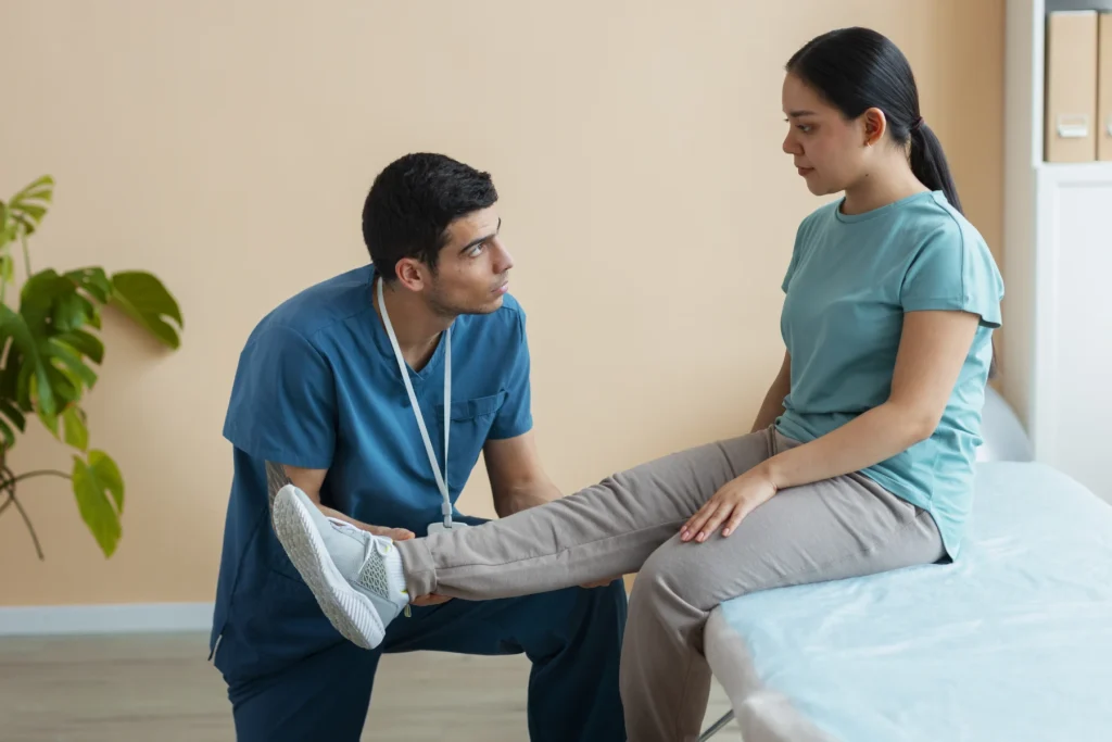 Physiotherapist assessing the lower leg of a seated patient