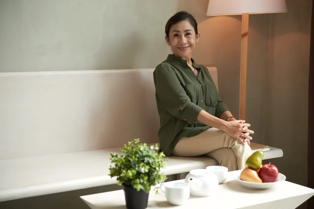 Woman relaxing on a sofa beside houseplants